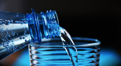 plastic water bottle pour into cup blue black